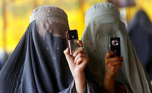 Dos jóvenes afganas con burka y teléfono movil.
