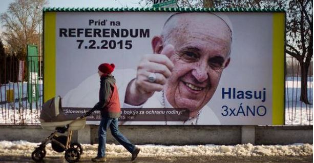 AFP/AFP/Archivos - Una mujer pasa en frente a una valla con el retrato del Papa Francisco, en Bratislava el 3 de febrero de 2015. La leyenda instando a las personas a votar en el referndum para mantener o prohibir el matrimonio homosexual en Eslovaquia